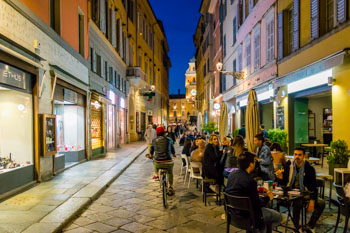 Bary na głównej ulicy (via Farini) wieczorem, Parma, Włochy
